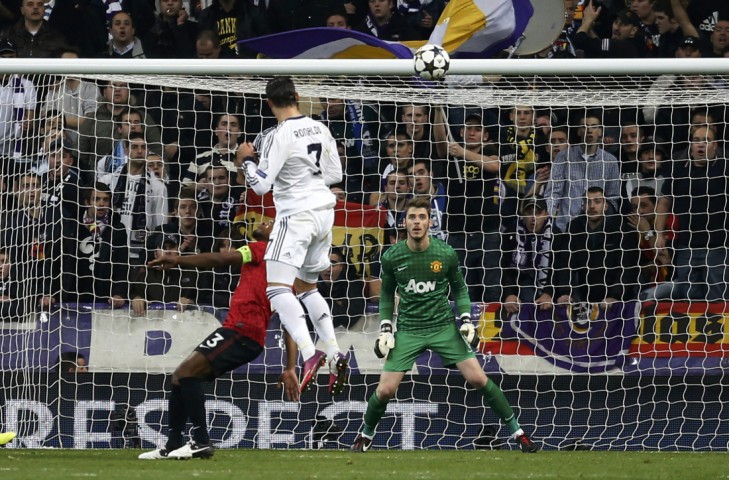 Real Madrid's Cristiano Ronaldo scores past Manchester United goalkeeper David De Gea (R) during their Champions League soccer match at Santiago Bernabeu stadium in Madrid February 13, 2013. REUTERS/Paul Hanna (SPAIN - Tags: SPORT SOCCER)