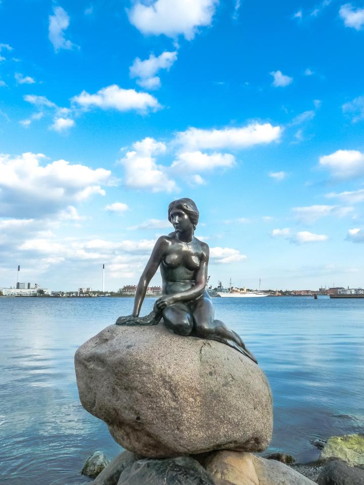 The Little Mermaid statue is often shown against a calm ocean background