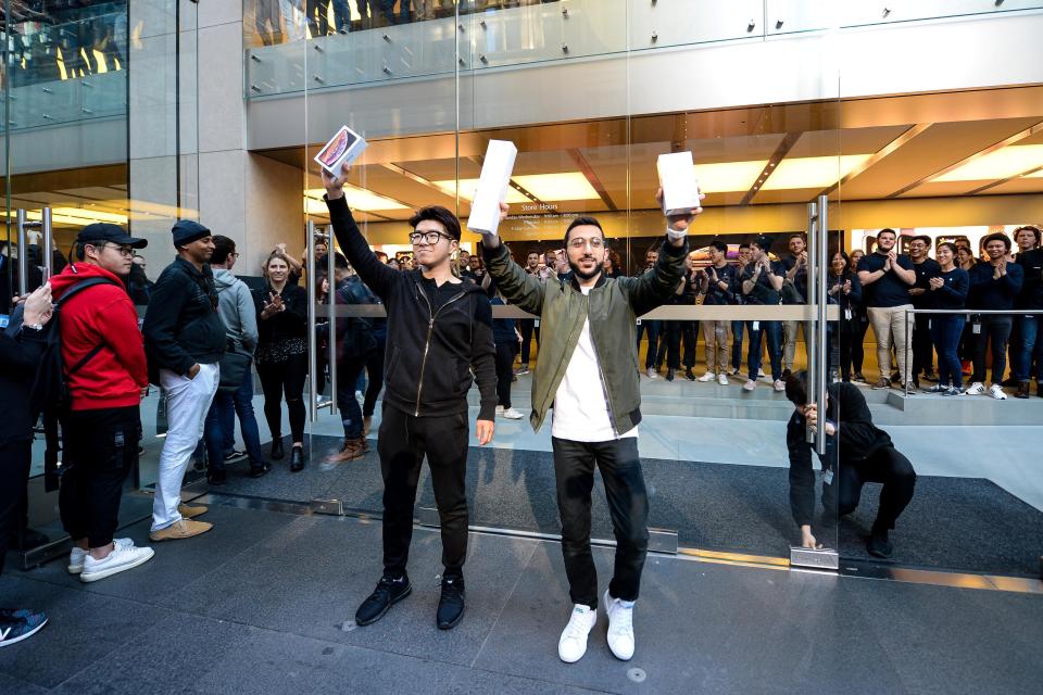 Sydney student Teddy Lee,right, and Mazen Kourouche, left, hold up their new iPhones after being the first customers in line for new products at the Apple Store in Sydney