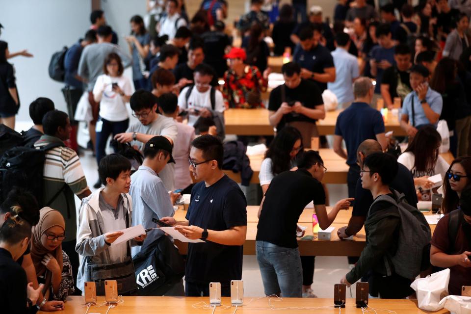 Customers look at the newly launched iPhone XS and iPhone XS Max at the Apple Store in Singapore 