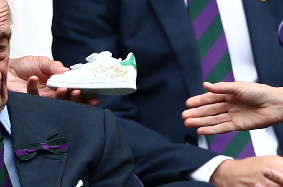 A signed Adidas Stan Smith trainer being given to Prince Louis.