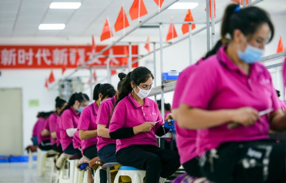 Workers at an electronics factory in in Aketao County, Xinjiang, work as part of the 'poverty alleviation' programme