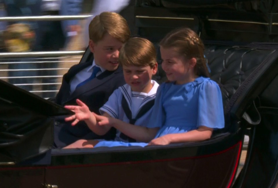 Charlotte places a hand over Louis' arm to stop him from frantically waving
