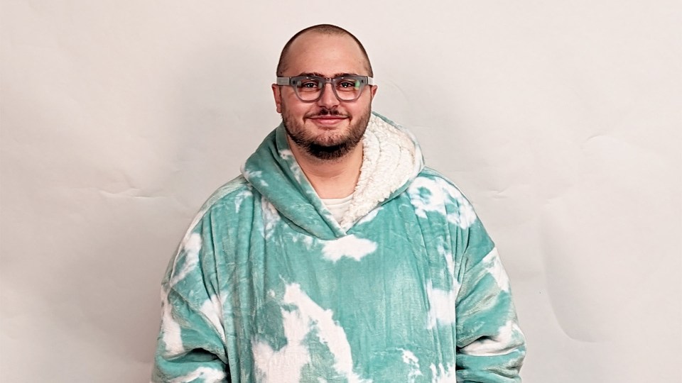 a man wearing glasses and a tie dye hoodie
