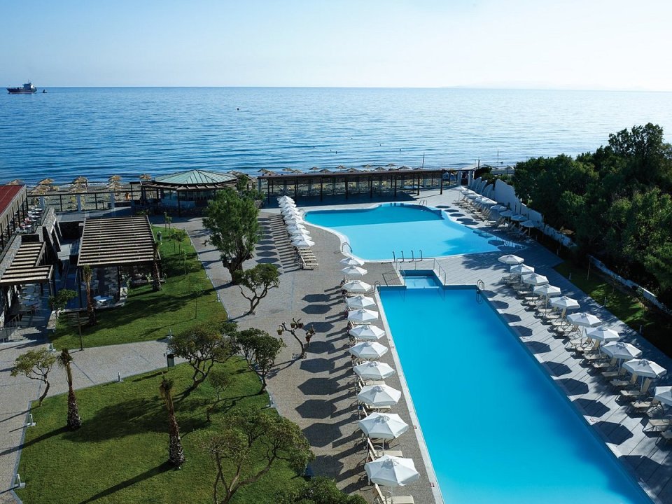 a large swimming pool surrounded by umbrellas and chairs