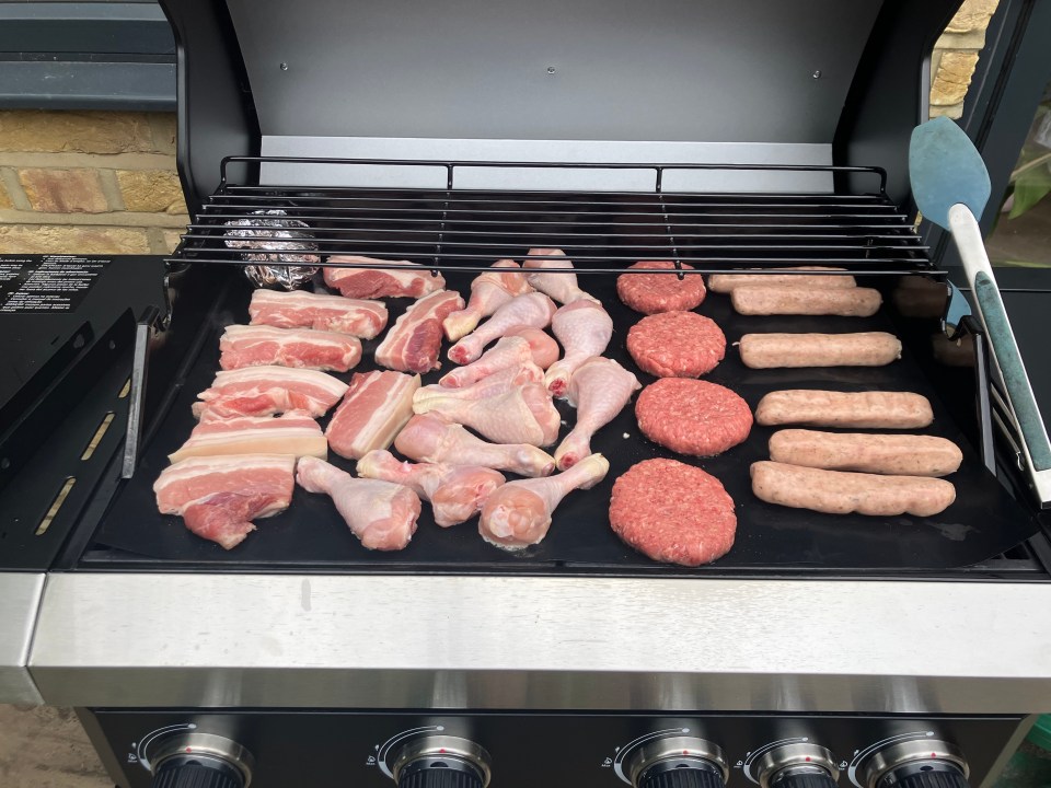 A grill, which is also known as a barbecue or BBQ, is a device that cooks food by applying heat from below. The heat can come from a variety of sources, including charcoal, gas, or electricity. Grills are often used to cook meats, vegetables, and fish. This grill has a black metal exterior and is surrounded by a white fence.