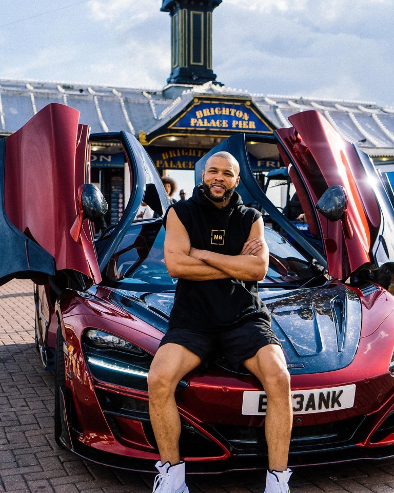 Chris Eubank Jr. sitting on a red McLaren sports car.