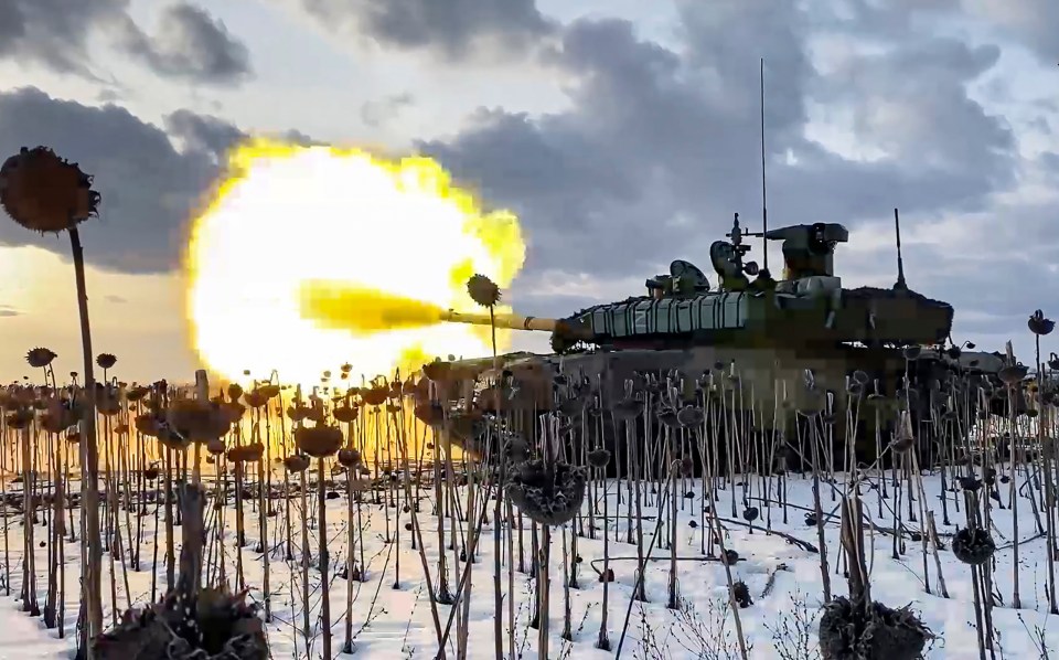a tank is firing a cannon in a field of flowers