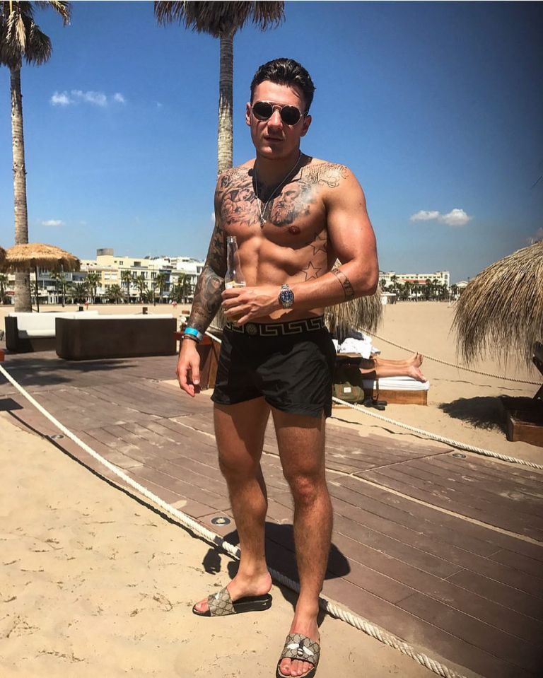 JJ hanging out on the beach in Versace shorts