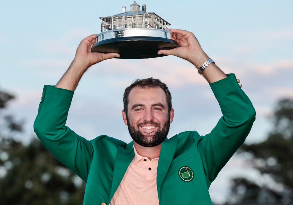 Jon Rahm and his wife holding the Masters Tournament trophy.
