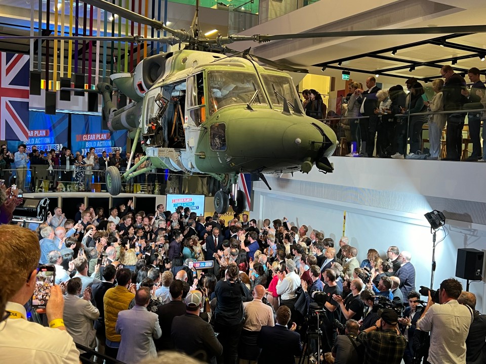 a crowd of people are gathered in front of a helicopter that says rescue plan
