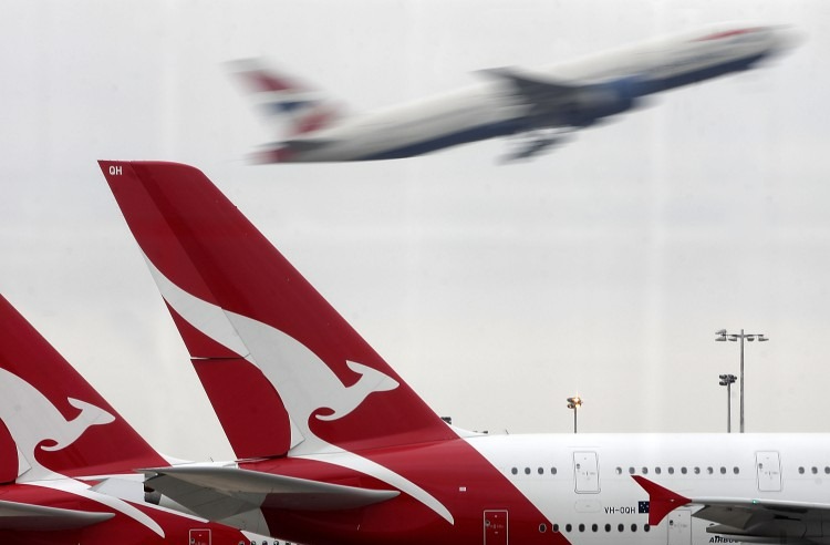 LONDON, ENGLAND - OCTOBER 30: As another airline's plane takes off, Qantas airline jets sit grounded on the tarmac at Heathrow airport on October 30, 2011 in London, England. Qantas' entire fleet of airplanes have been grounded until further notice due to an ongoing industrial dispute leaving thousands of passengers stranded across the world. (Photo by Matthew Lloyd/Getty Images)