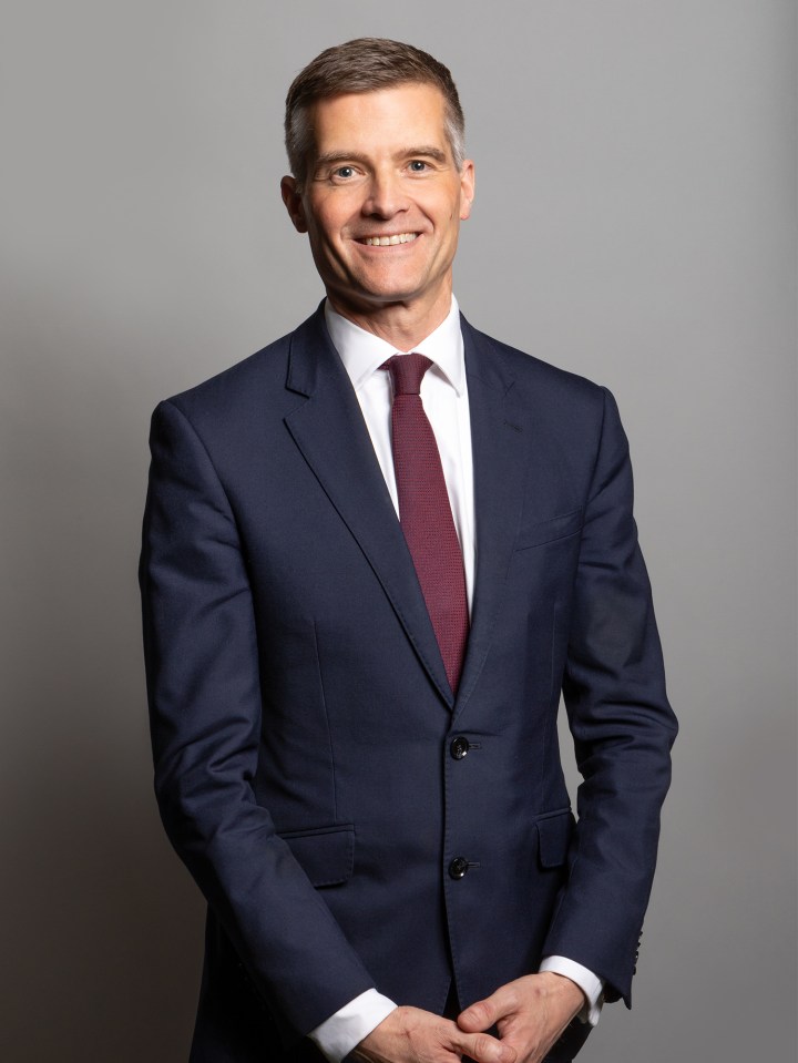 a man in a suit and tie smiles for the camera