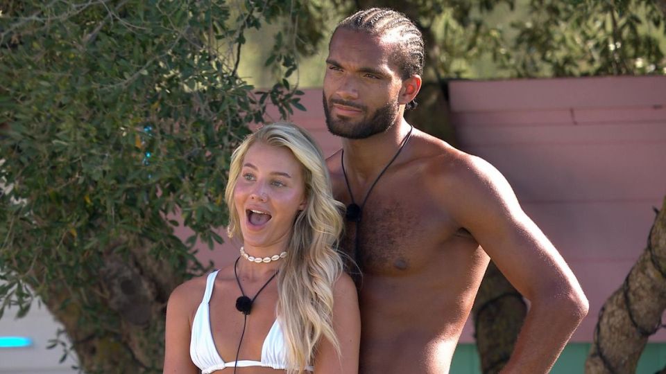 a man without a shirt is standing next to a woman in a bikini
