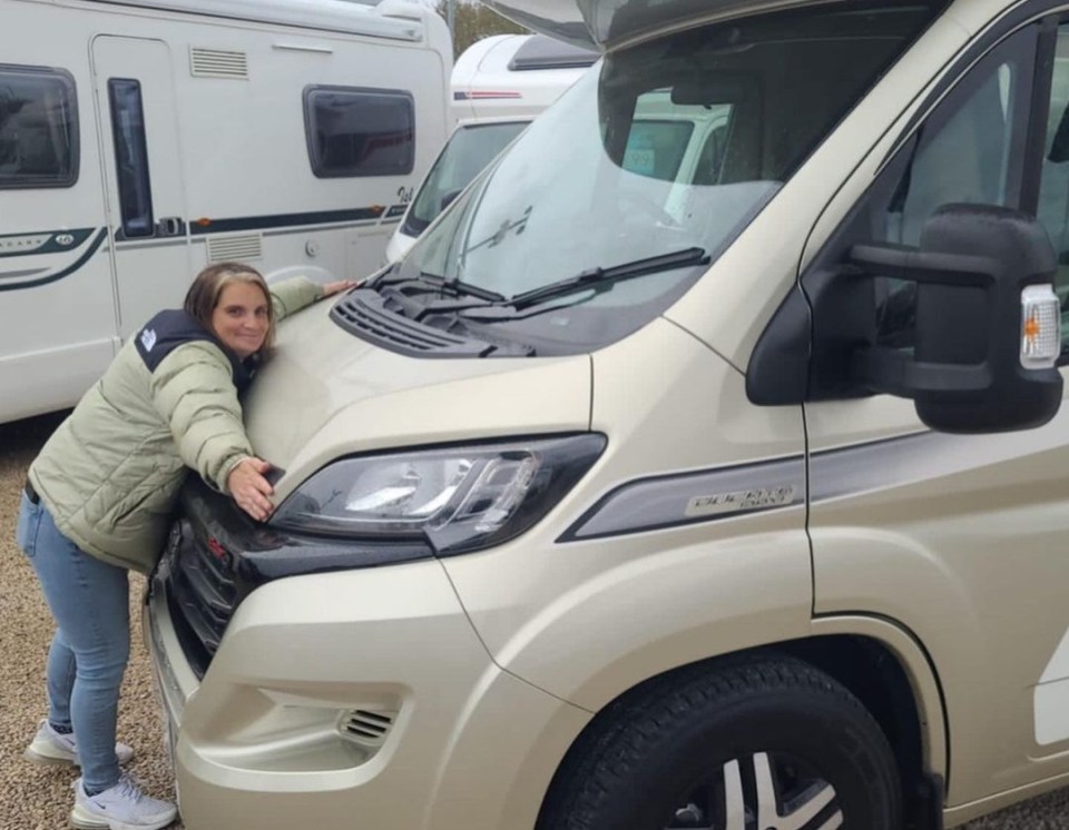 a woman leans on the front of a camper van that says crew