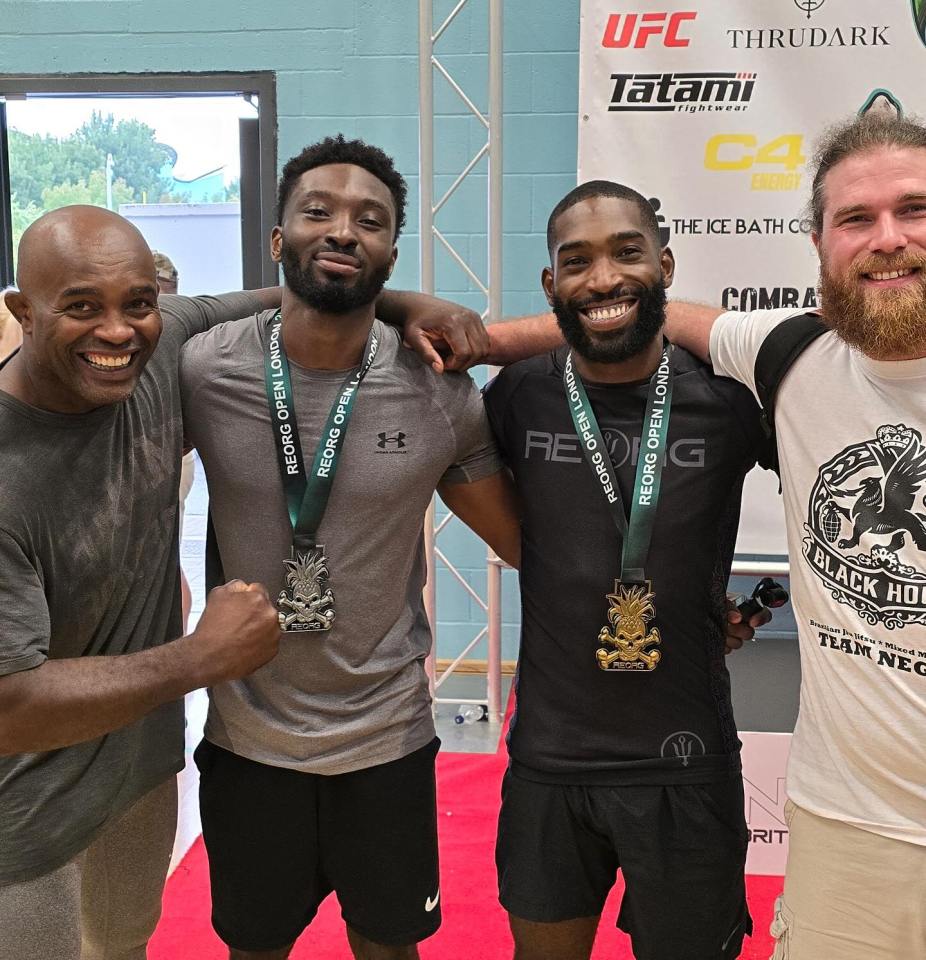 four men are posing for a picture in front of a banner that says ufc