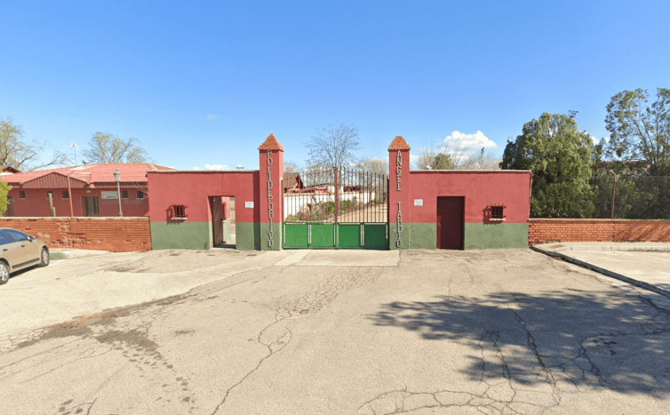 a car is parked in front of a red and green building