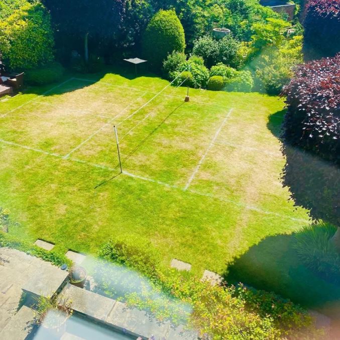an aerial view of a tennis court in a backyard