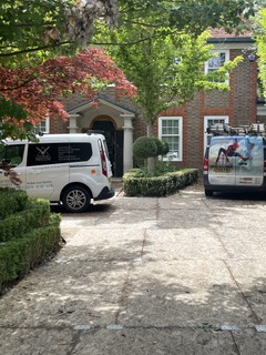 two vans are parked in front of a brick house .