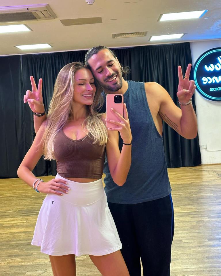 a man and a woman are posing for a picture in a dance studio
