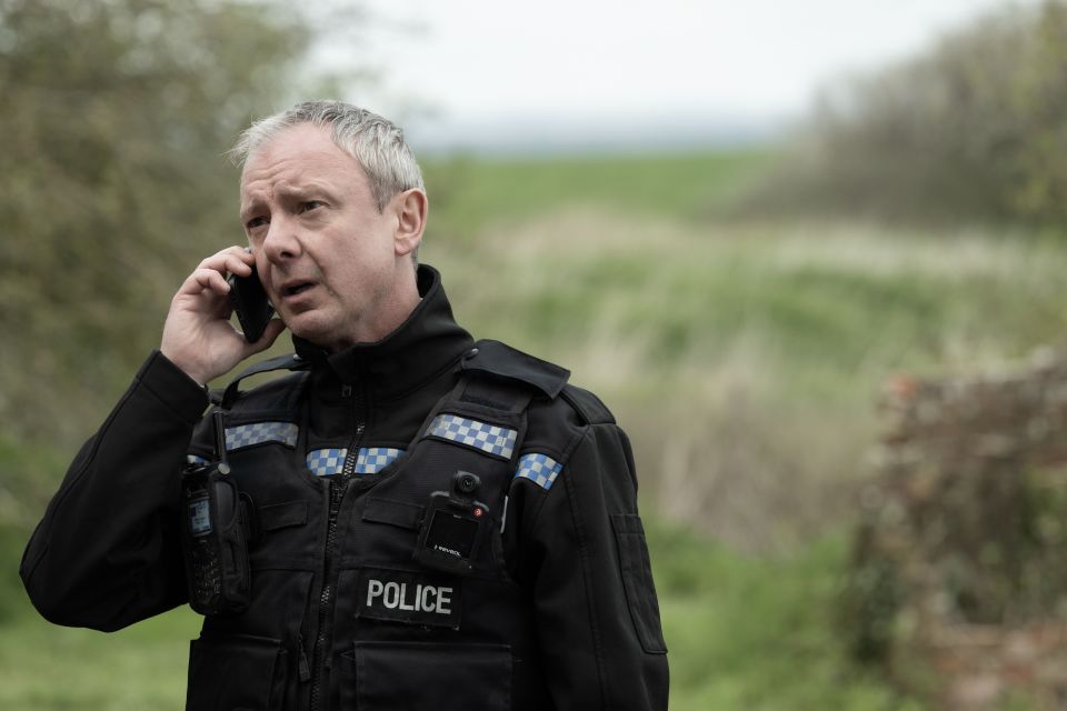 a police officer is talking on a cell phone