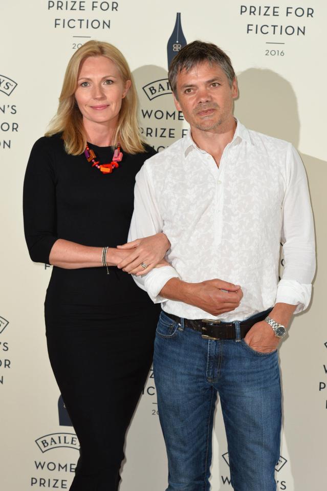 a man and a woman stand in front of a wall that says prize for fiction