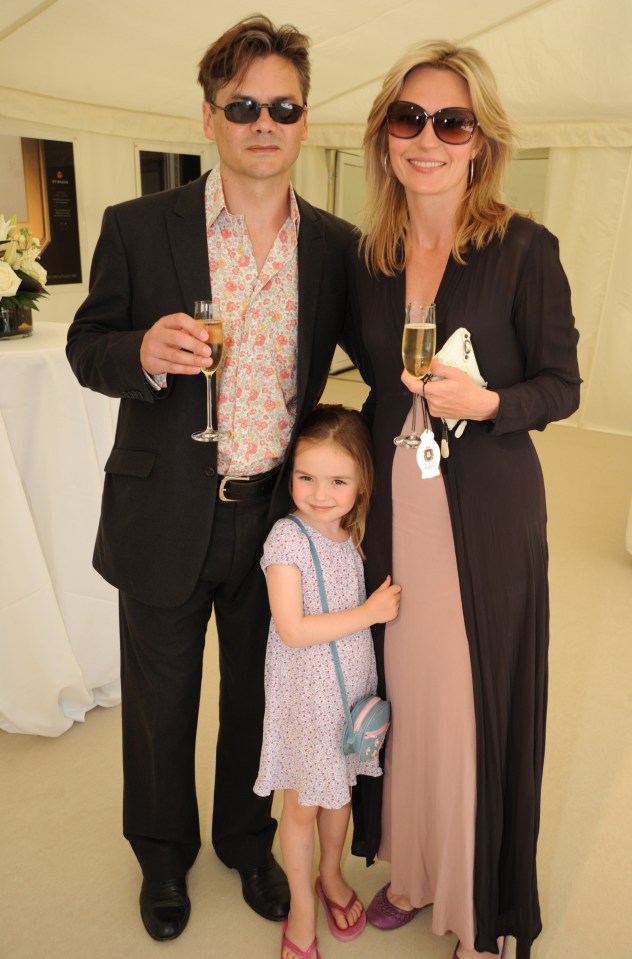 a man and woman standing next to a little girl holding glasses of champagne