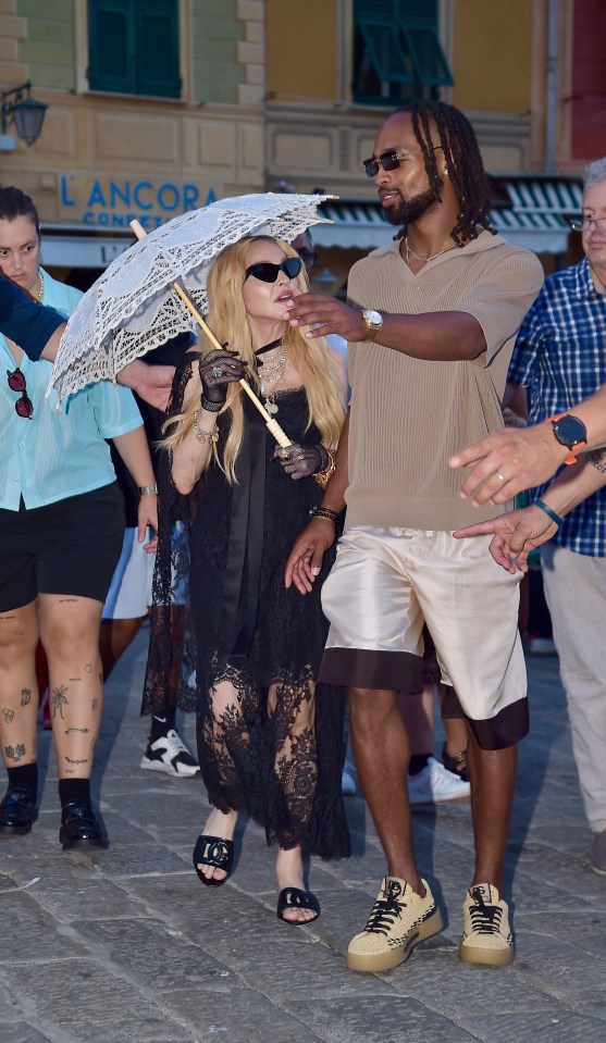 a woman in a black dress holding an umbrella in front of a lancome store