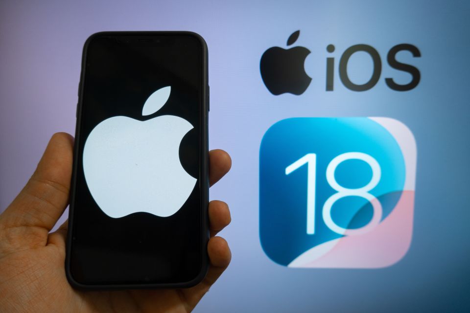 a person holding a phone with the apple logo on it