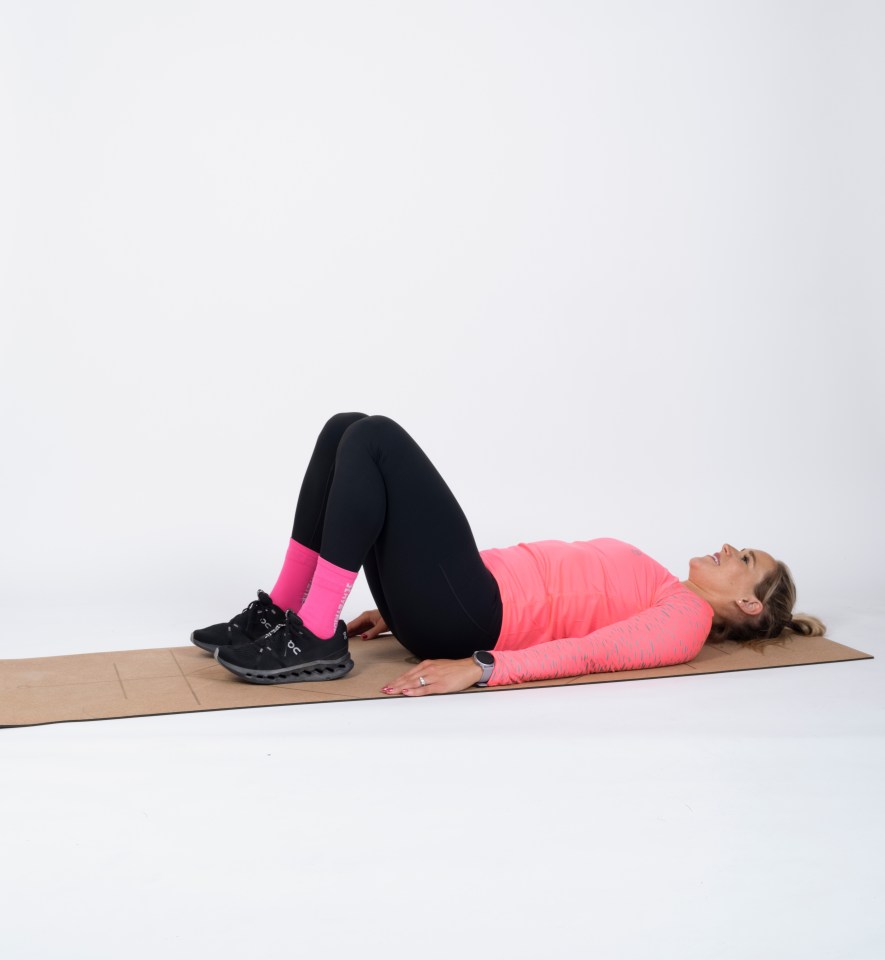 a woman in a pink shirt and black pants is laying on the floor