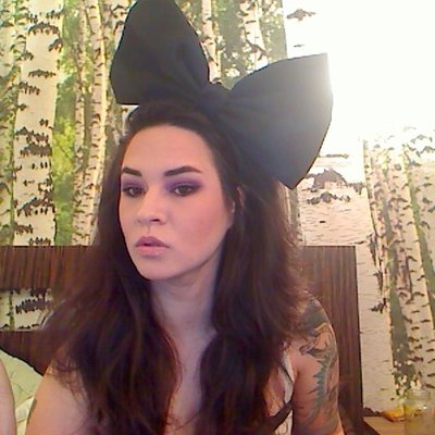 a woman is wearing a large black bow on her head .