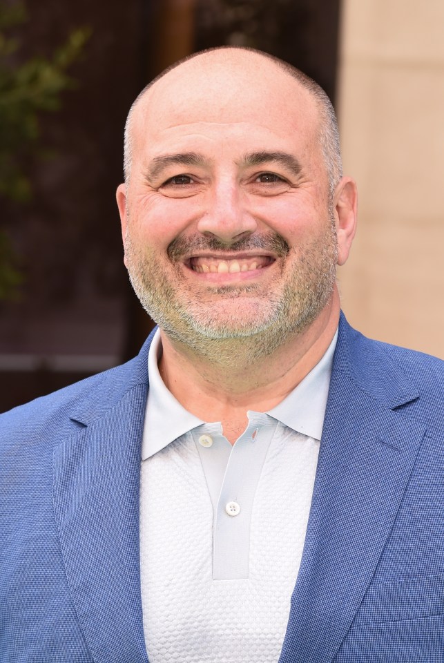 a bald man with a beard is smiling for the camera