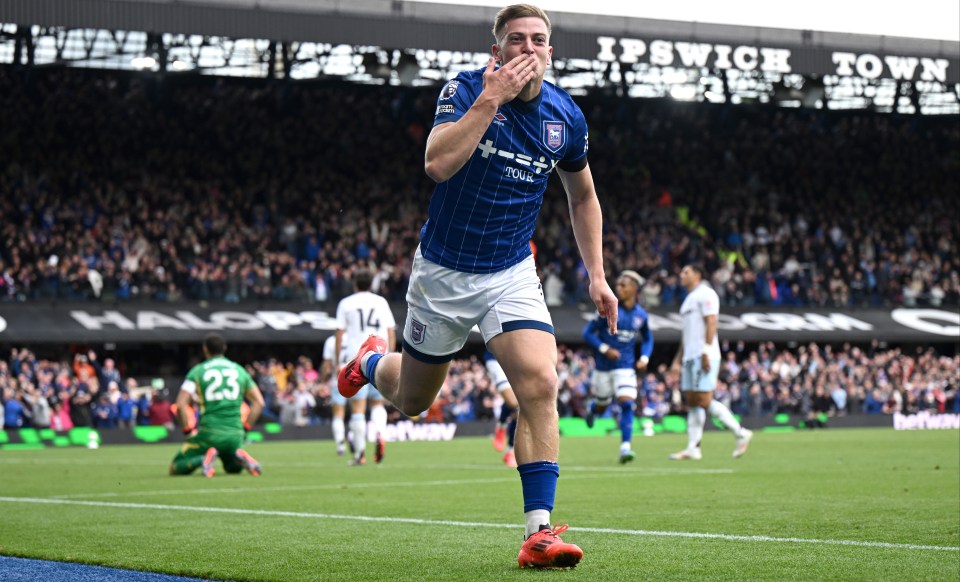 a soccer player wearing a blue shirt that says ipswich town