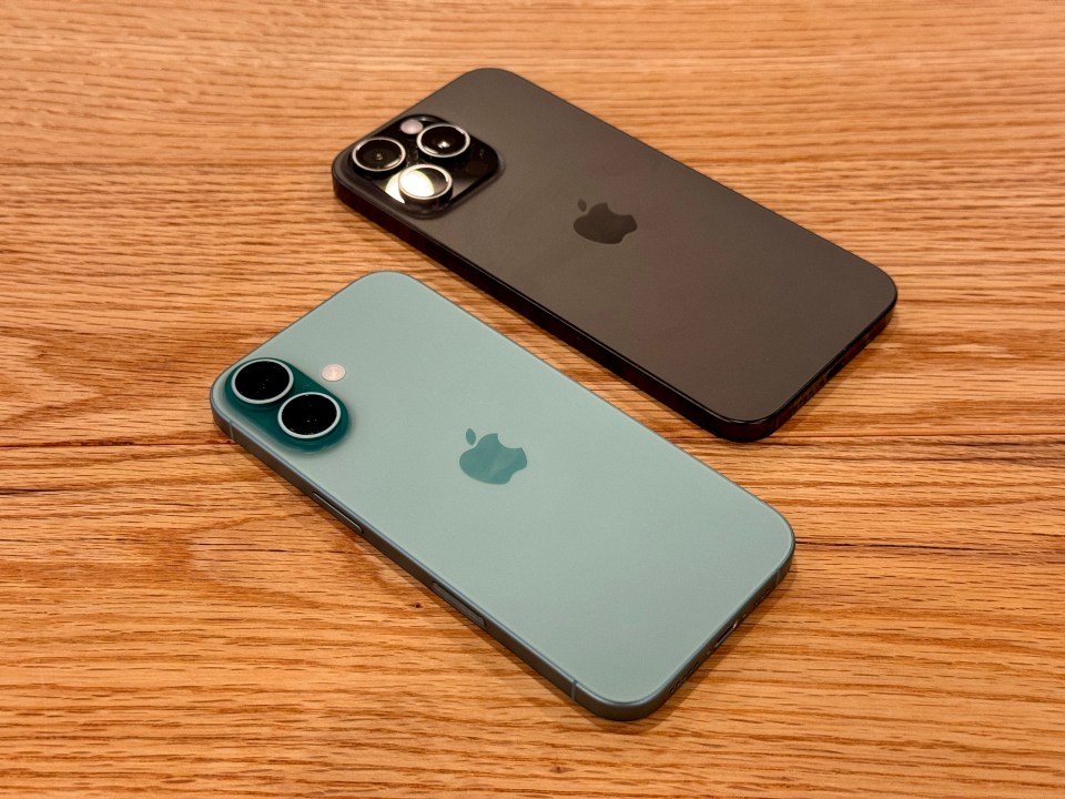 two apple phones are laying on a wooden table
