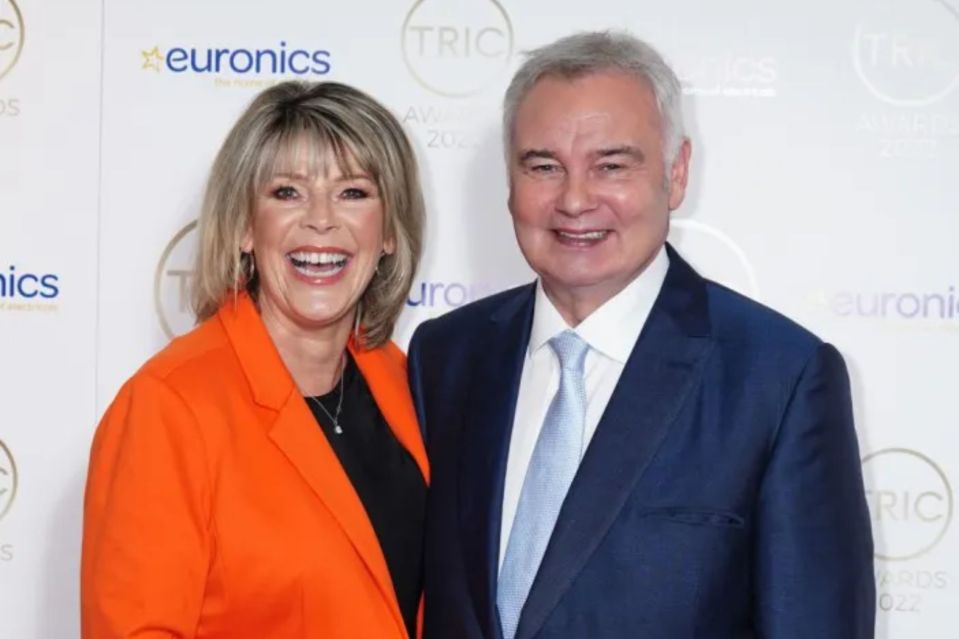 a man and woman are posing for a picture in front of a wall that says euronics
