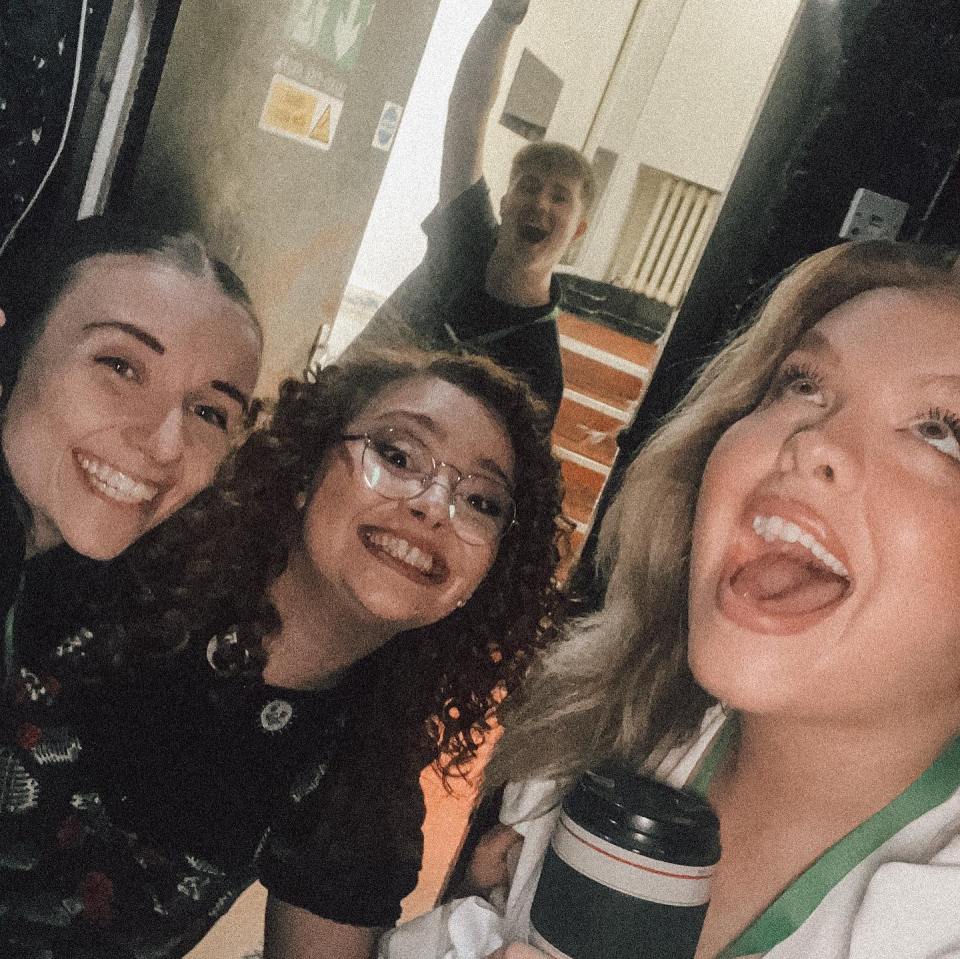 a group of people are posing for a picture in front of an exit sign