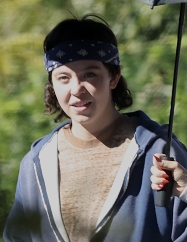 a woman wearing a bandana and holding an umbrella
