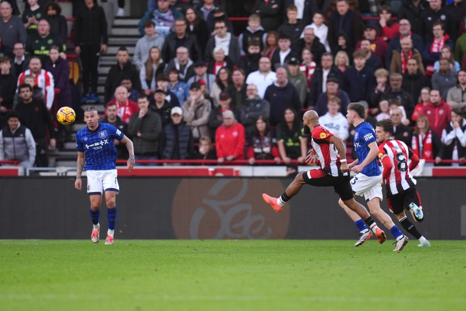 soccer players on a field with one wearing a blue jersey that says ' everton ' on it
