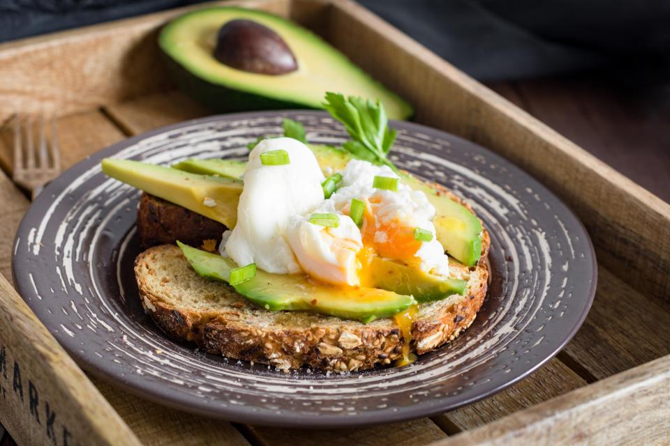 a sandwich with avocado and poached egg on a plate