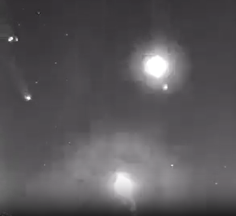 a black and white photo of a fireworks display in the night sky .