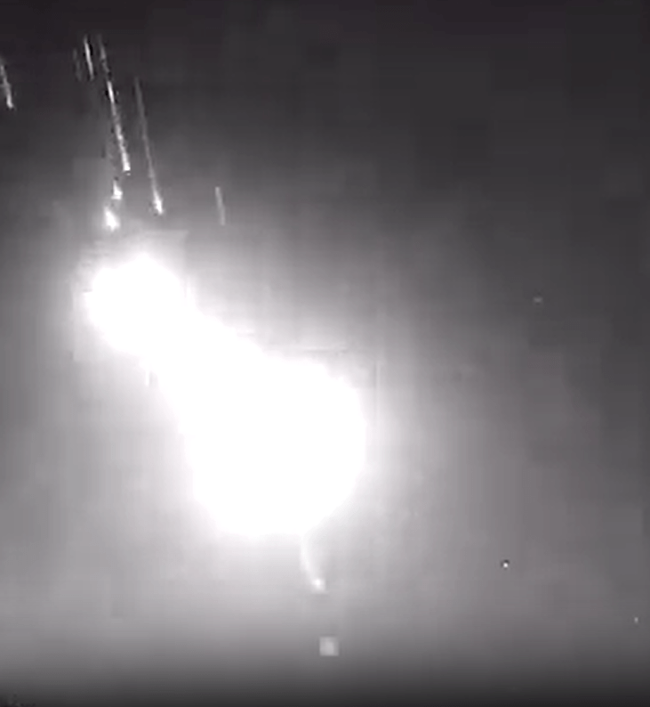 a black and white photo of a fireworks display in the night sky .