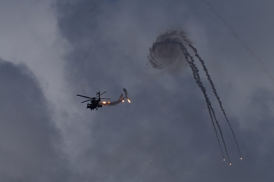 a helicopter is flying through a cloudy sky with smoke trails