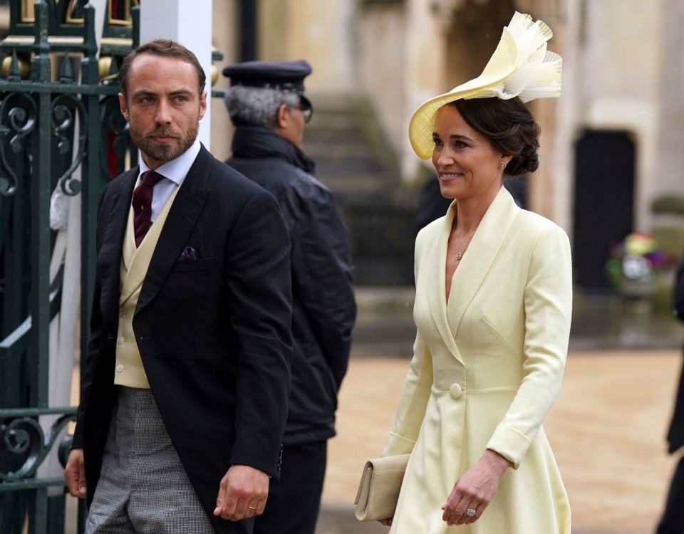 a man in a black suit and tie stands next to a woman in a yellow dress
