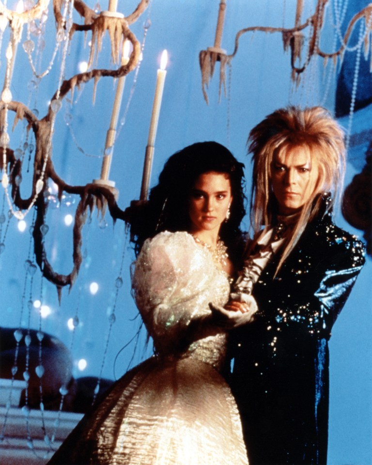 a man and a woman standing next to each other in front of a chandelier