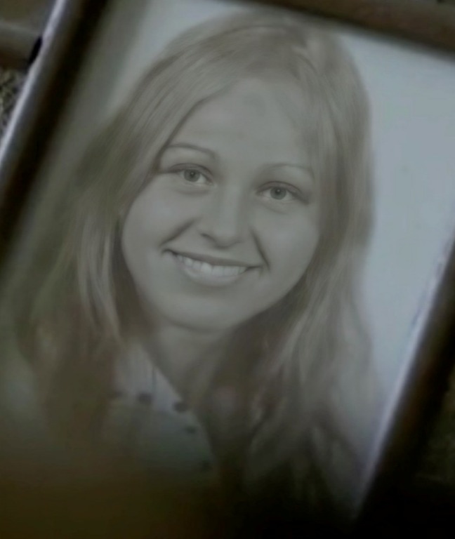 a black and white photo of a smiling woman