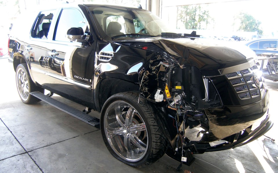a black escalade with a damaged front end