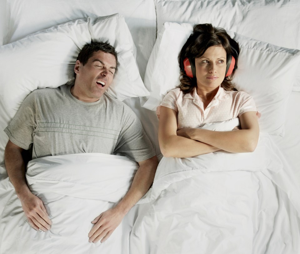 a man snoring next to a woman wearing ear plugs