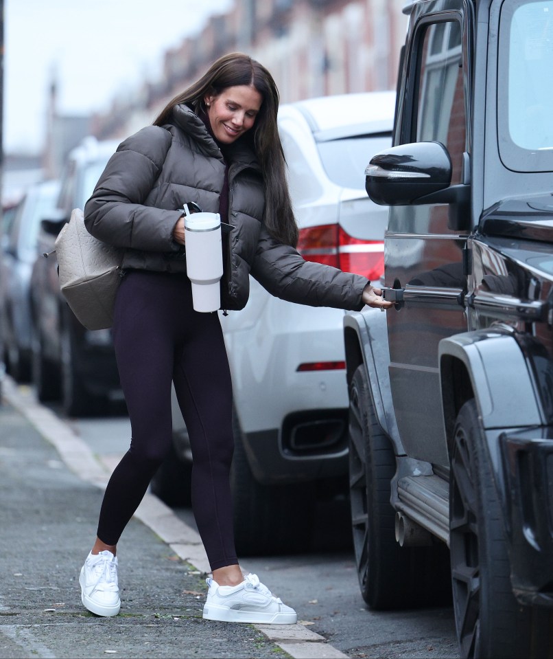 a woman in a puffer jacket is getting out of a car