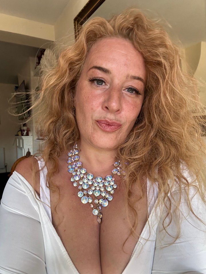 a woman wearing a white top and a necklace with rhinestones