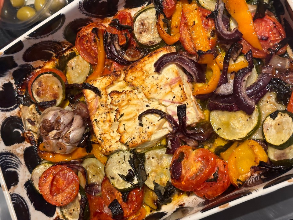 a casserole dish filled with vegetables and a piece of cheese